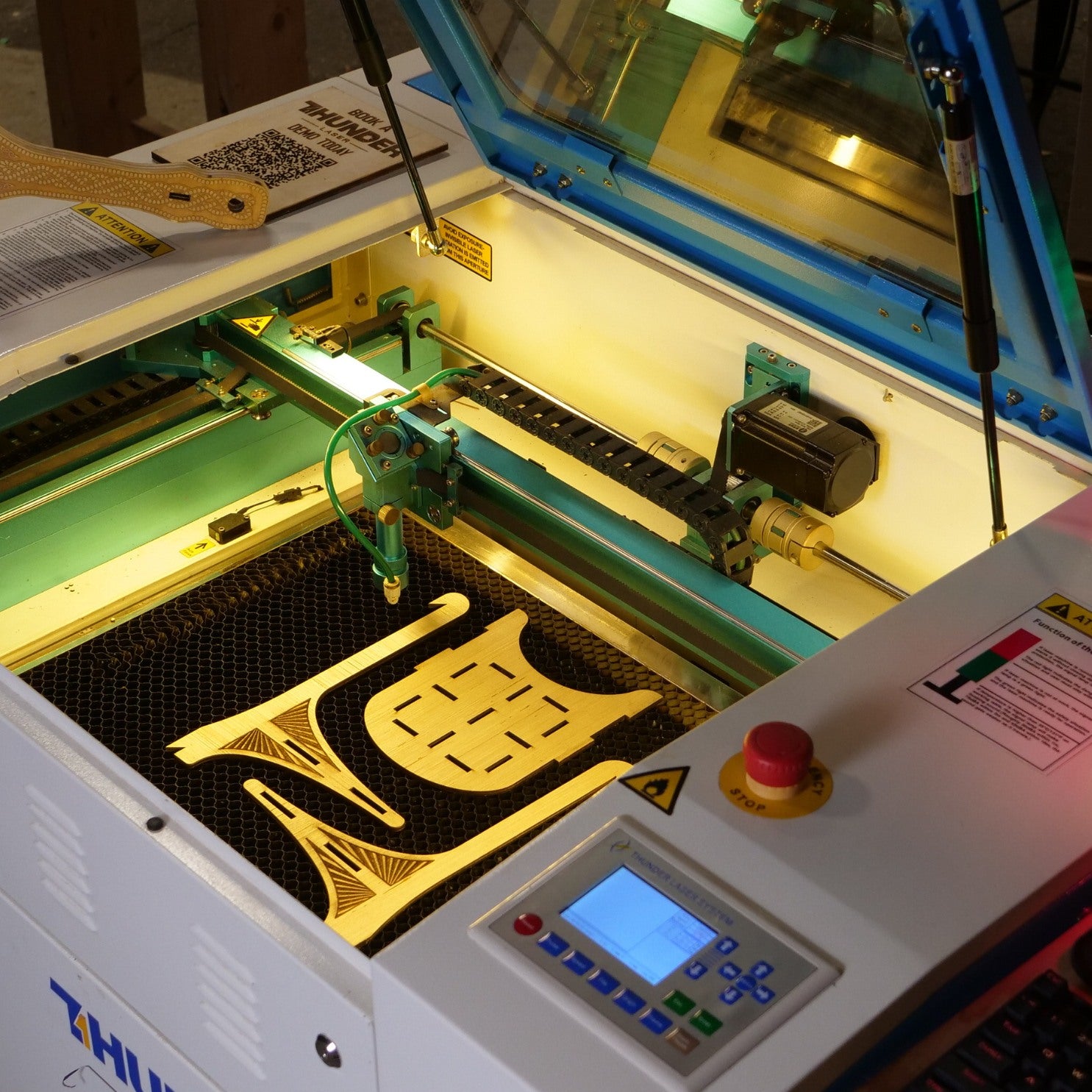 Close up of the inside Nova 24 Laser cutter by Thunder Laser Canada. Wood pieces sit on the bed of the laser